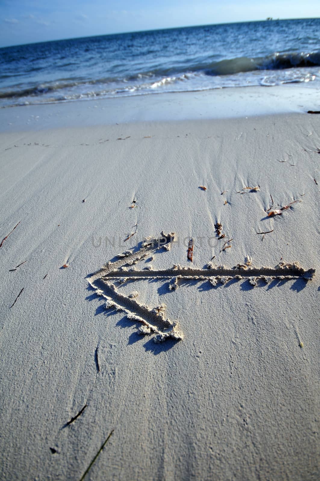 Destination - Arrow on the Beach Sand. Atlantic Ocean - Go Left.