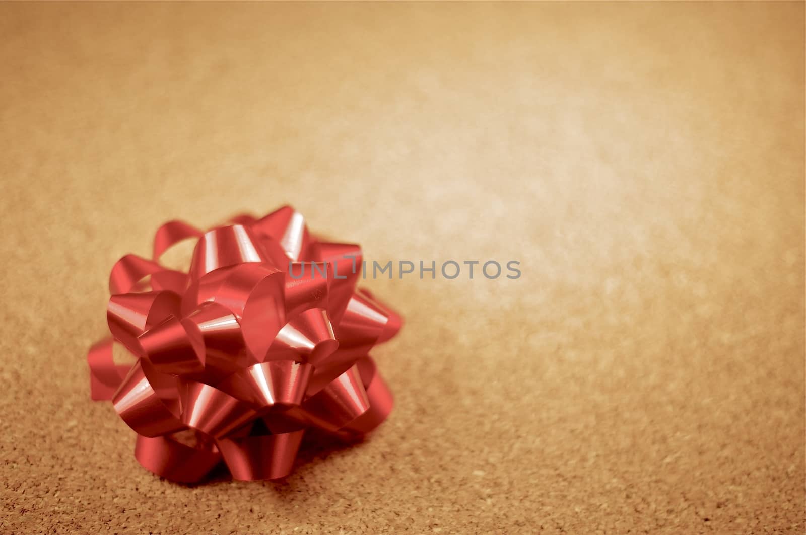 Small Burgundy Glossy Bow on the Cork Background. Bow Ornament.