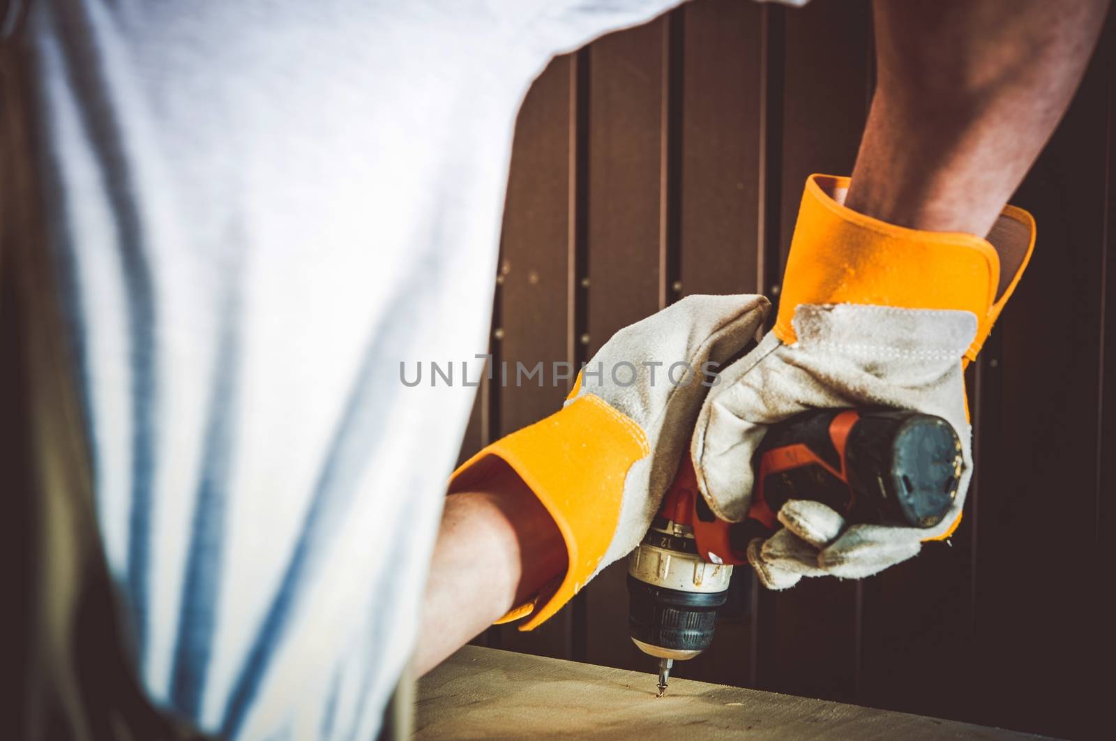 Small Repairs Home Job. Men with Electric Screwdriver Making Wooden Shelf Repair.