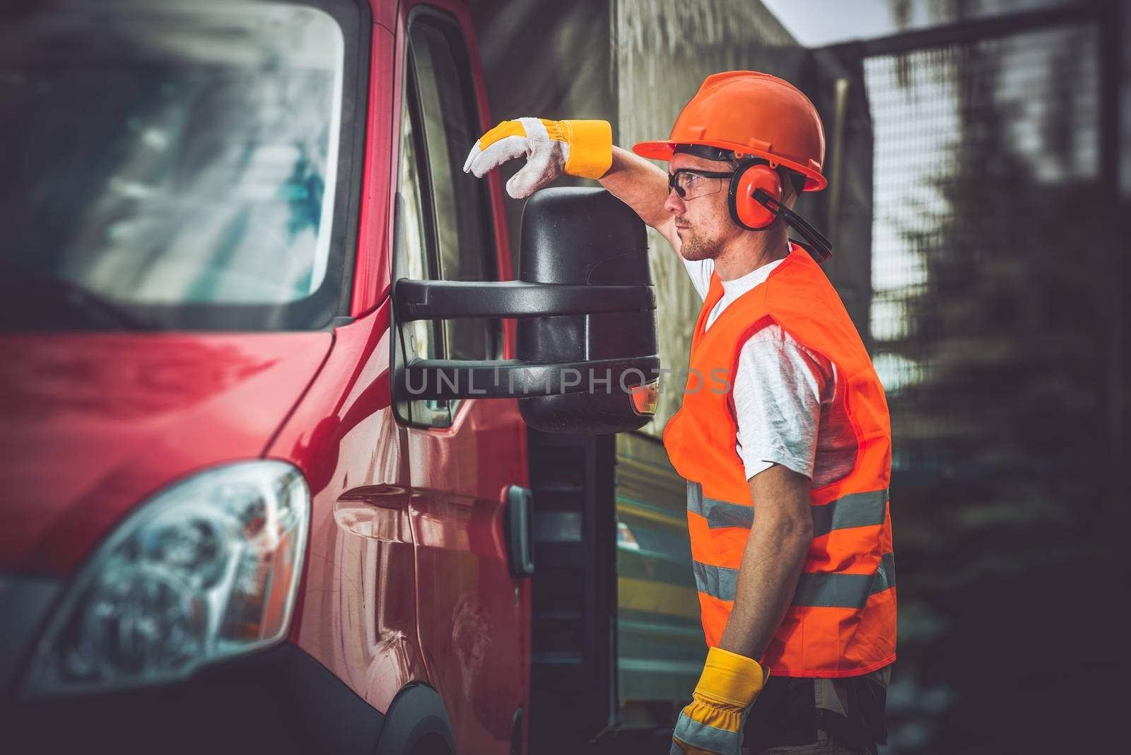 Worker and His Truck. Hard Working Men Wearing Construction Safety Accessories.