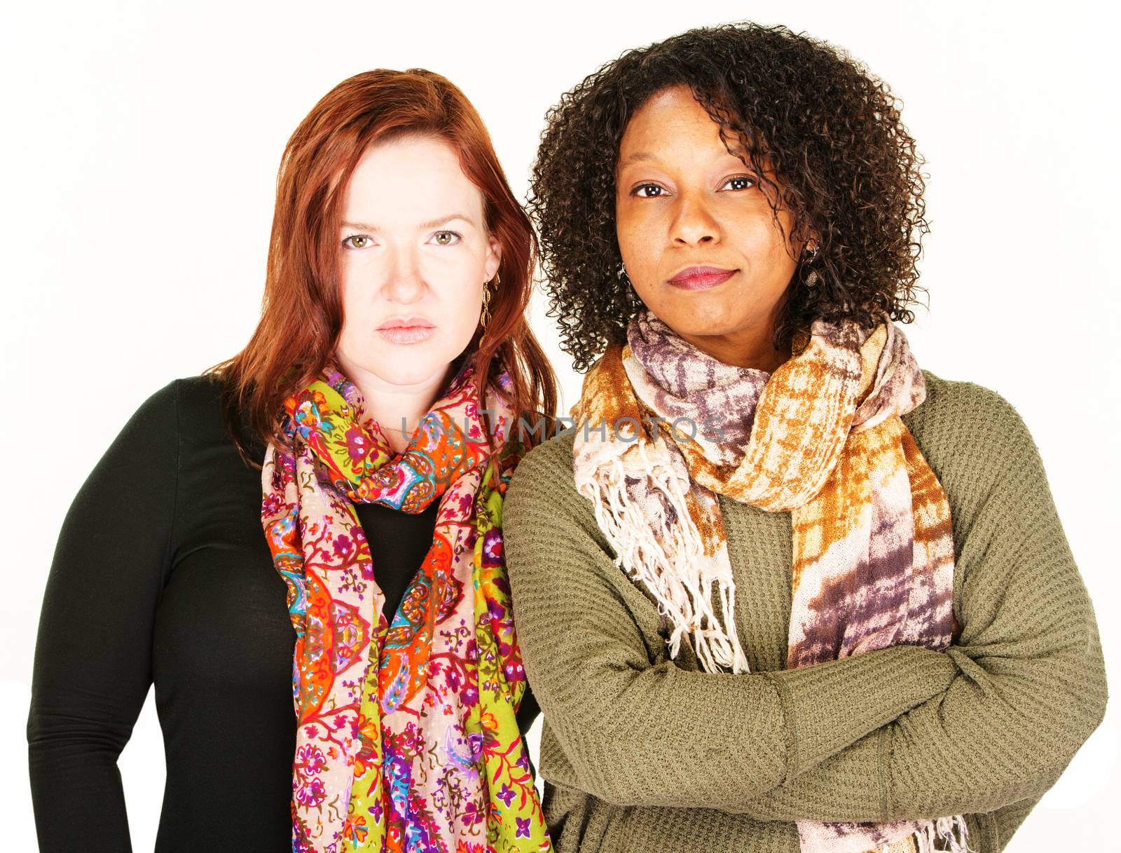 Two beautiful adult female friends with serious expression over white background