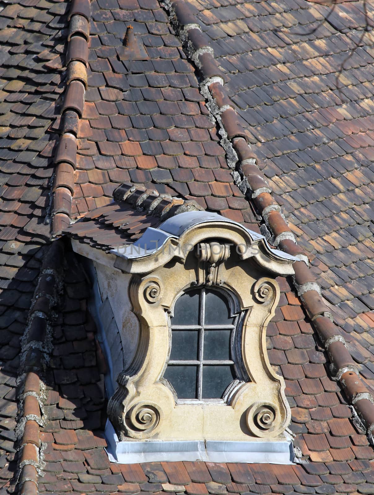 weathered old ornate dormer windows and roof tiles.
