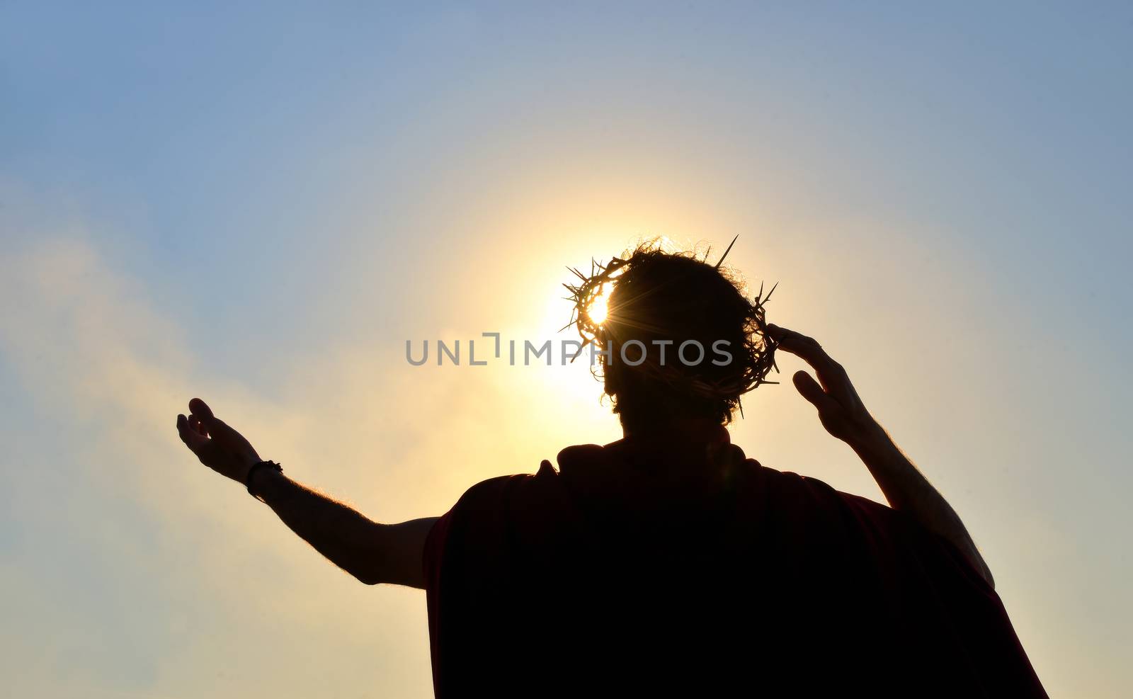 Jesus Christ with crown of thorns against the sun