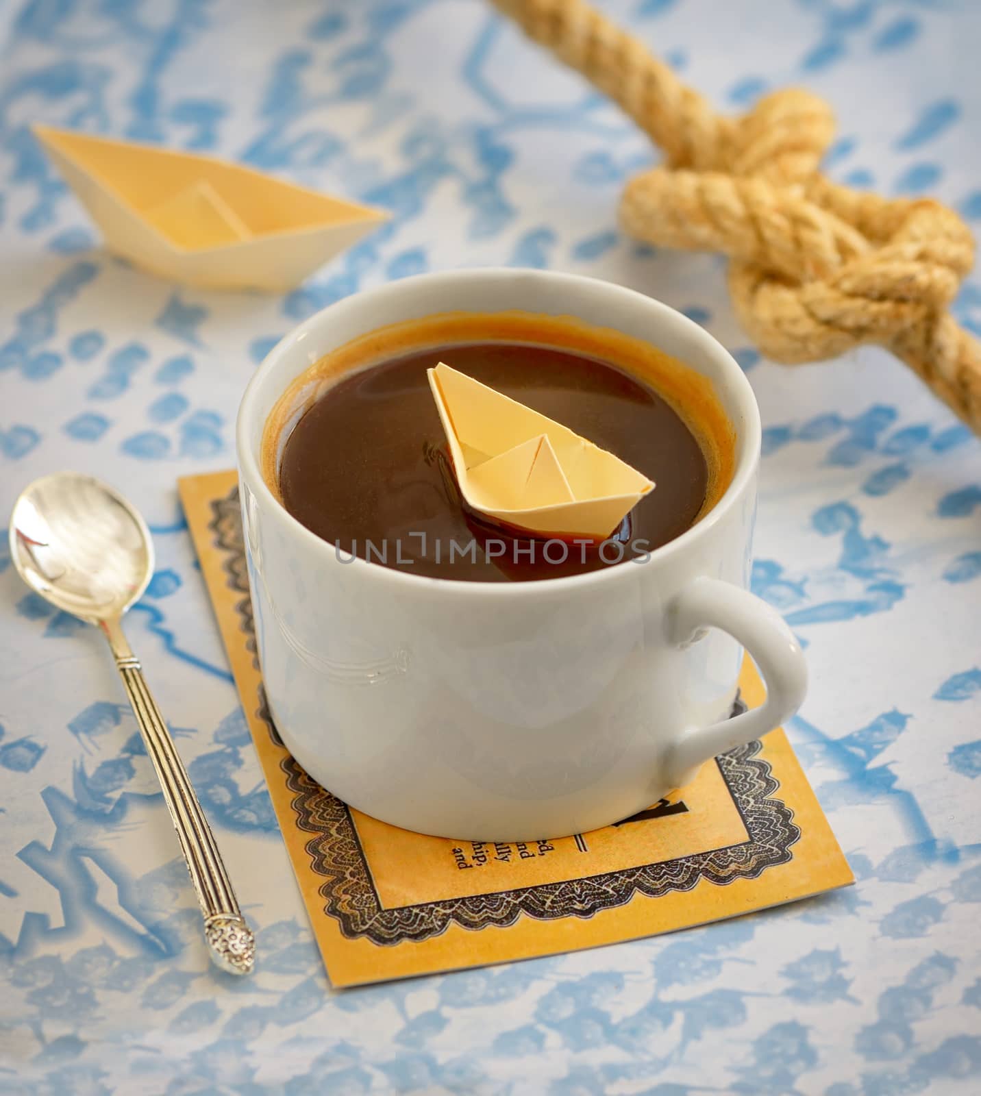 coffee cup and paper boat on map