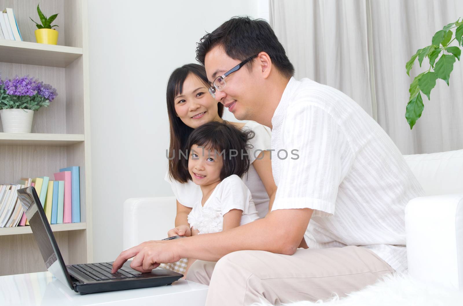 Asian family using laptop to perform online shopping