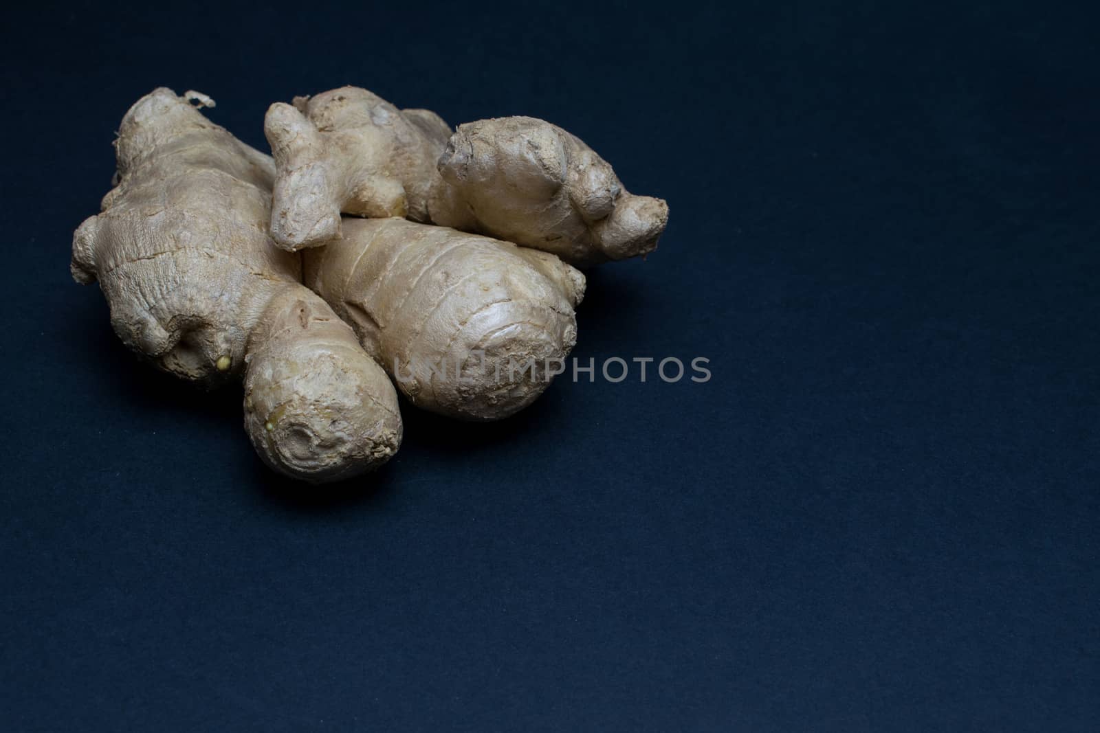 Ginger root disposed on a dark background