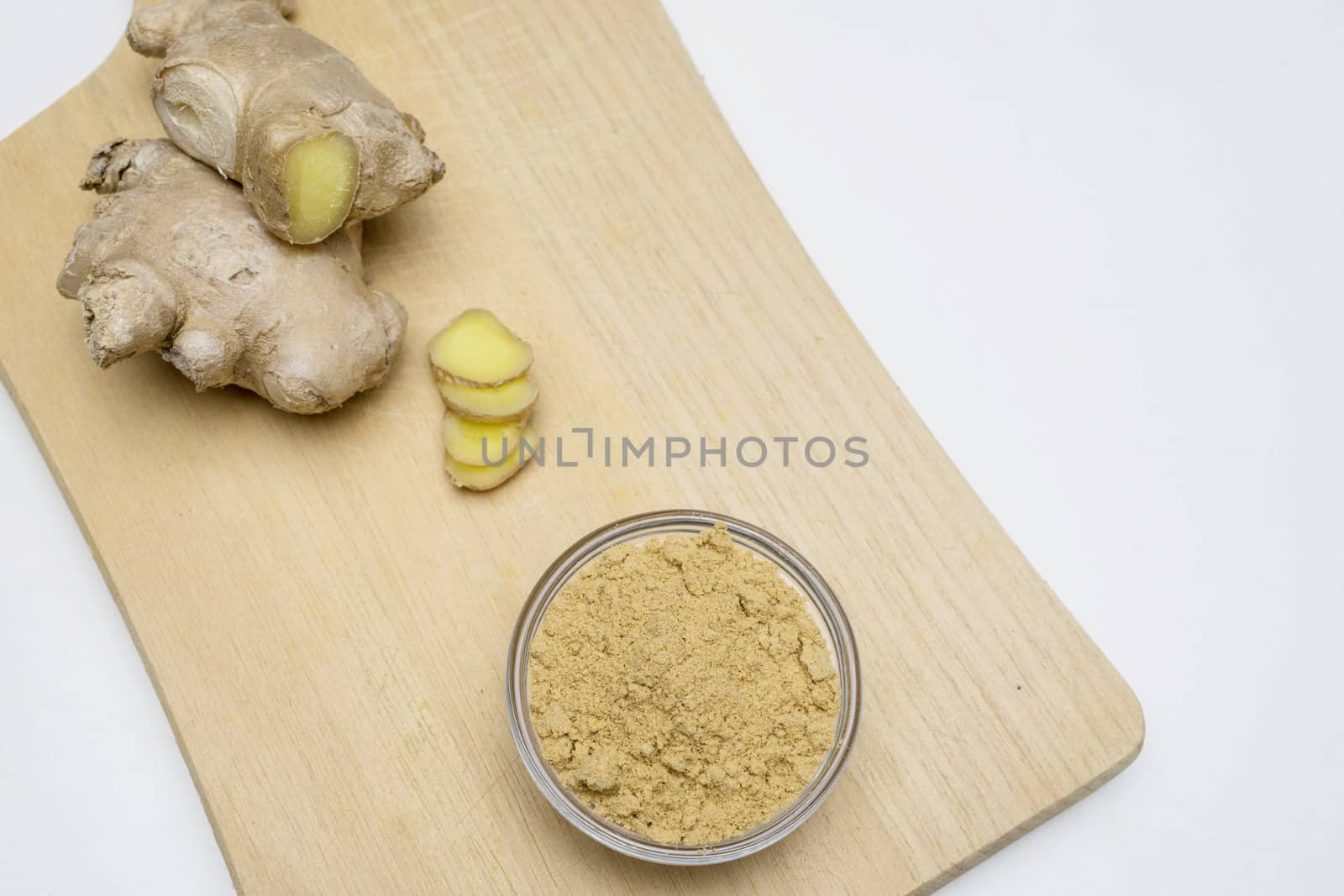 Ginger root, slices and powder on a white background