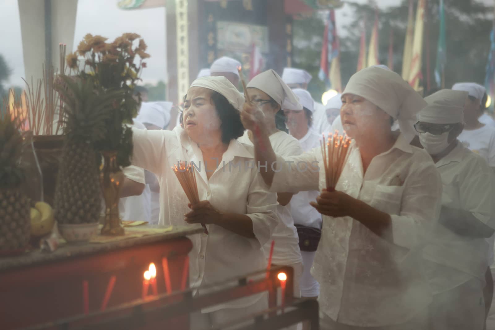 view of people burning candles during vegetarian festival in Thailand