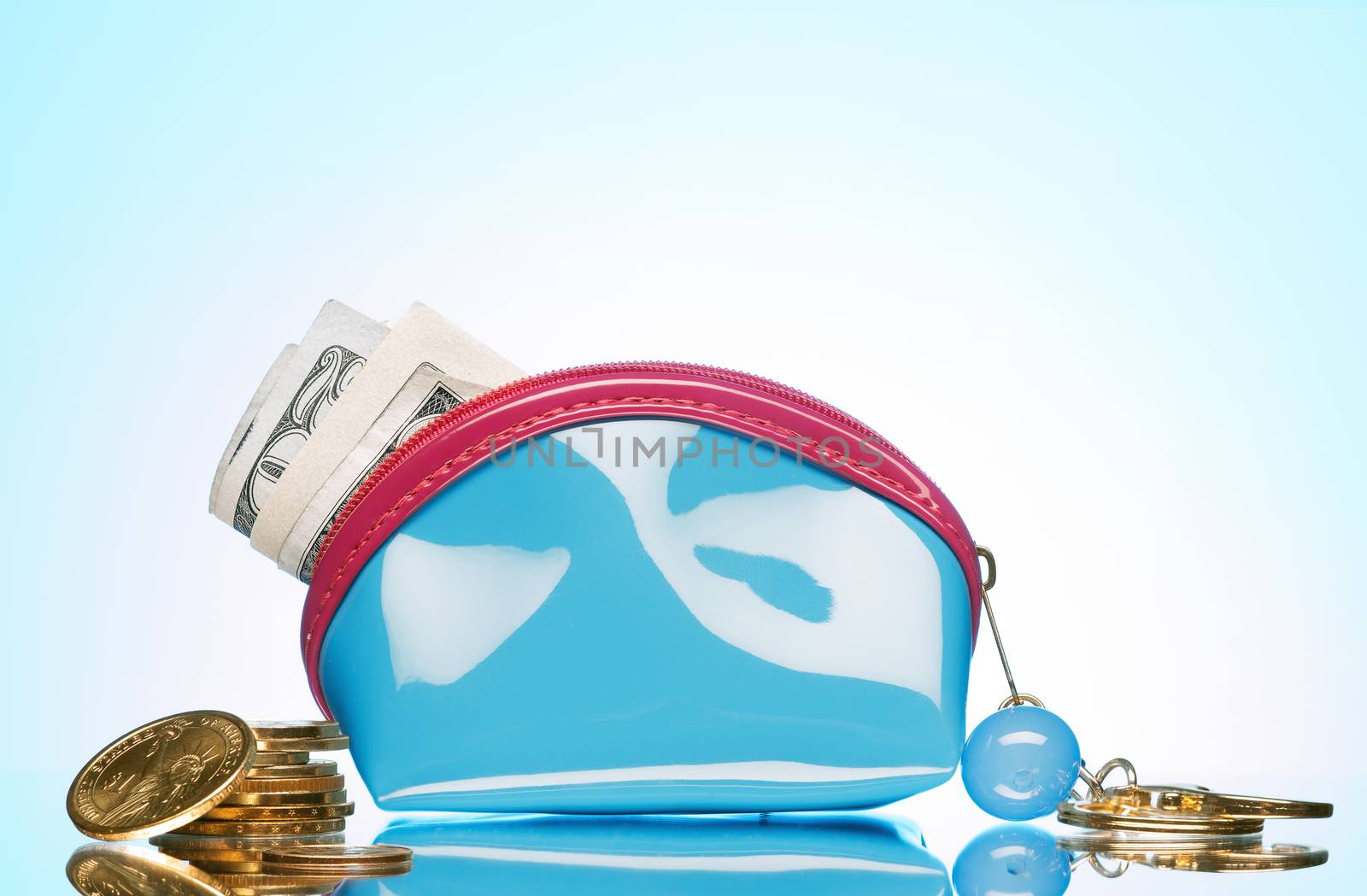 close up view of blue purse filled with cash on color back