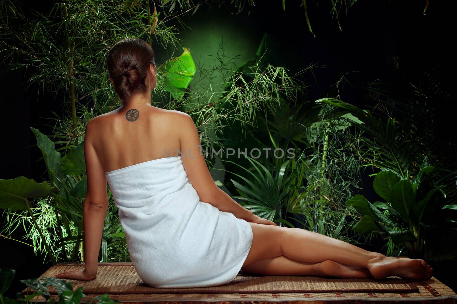 View of nice young woman meditating in spa tropic environment