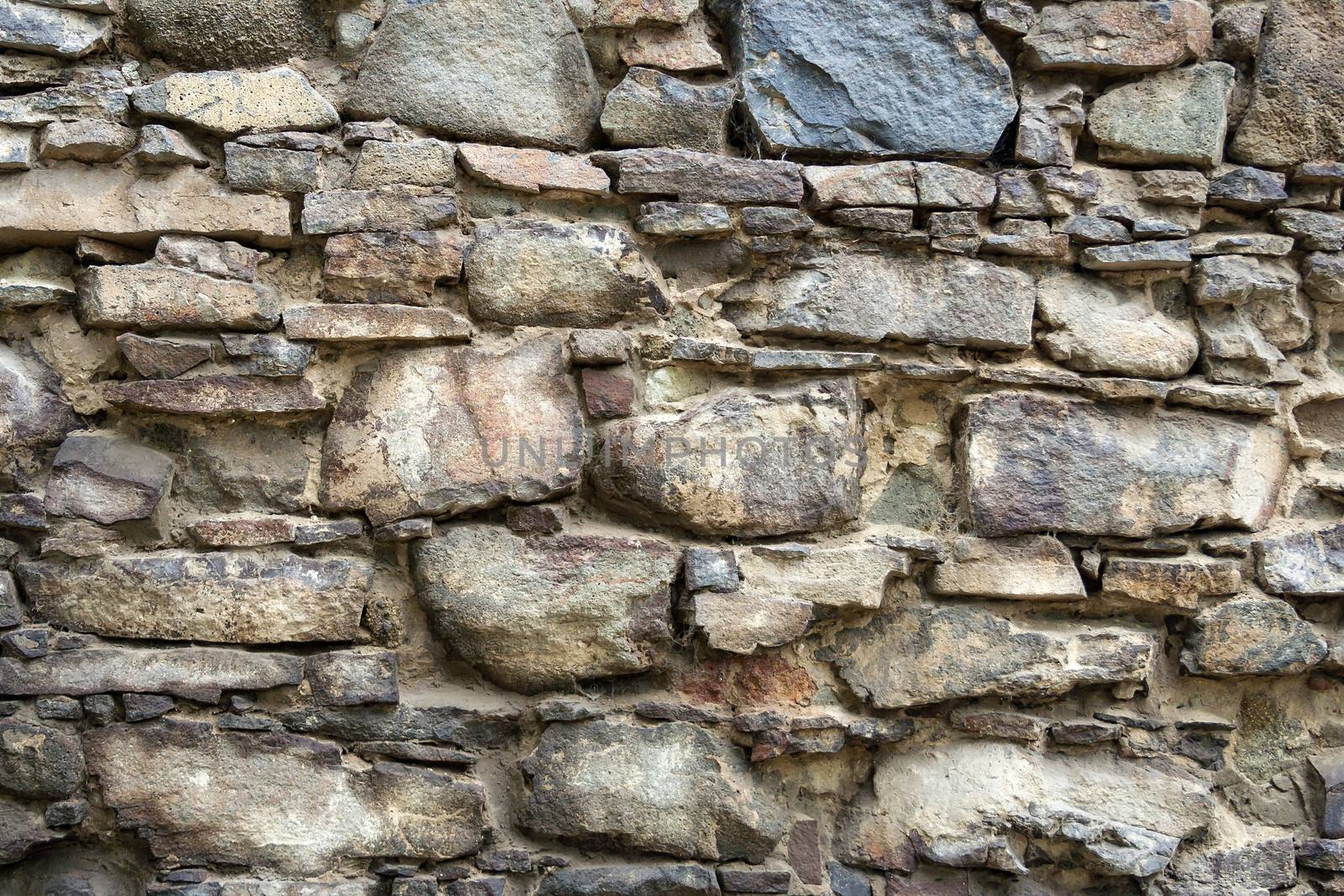 irregular texture of the old stone wall outside