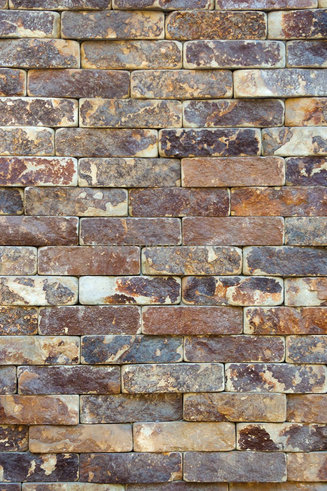 regular texture of the old yellow stone wall outside