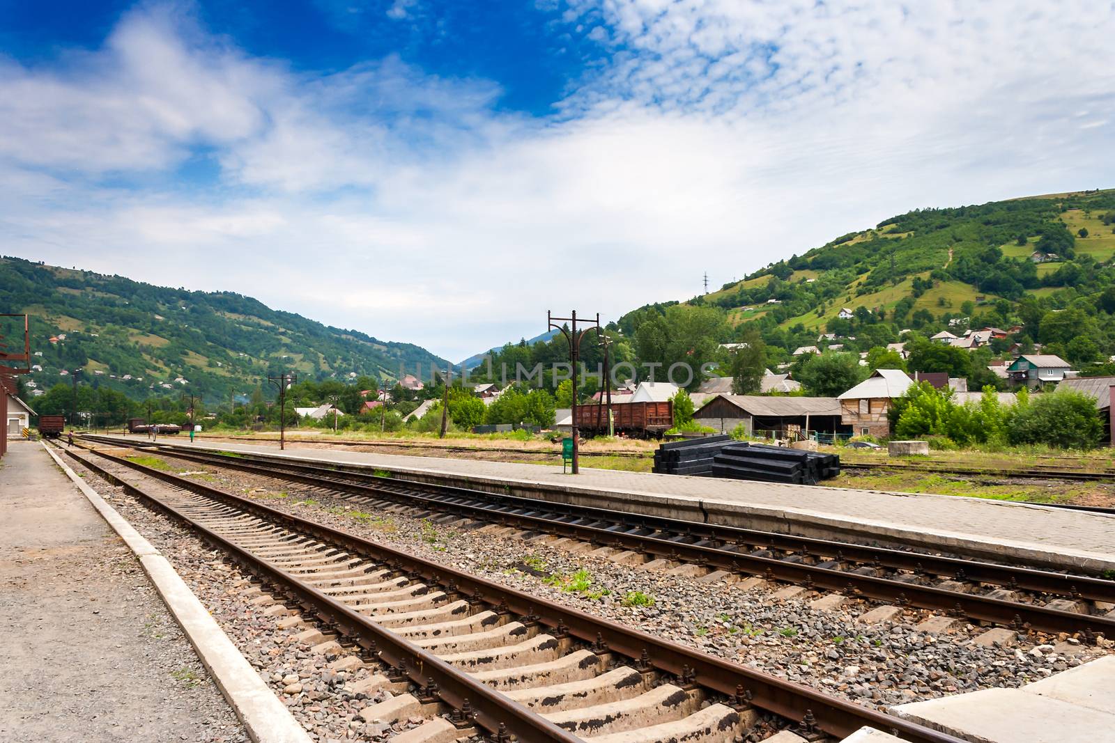 railroad of railway station in countryside which goes through the mountains under blue sky
