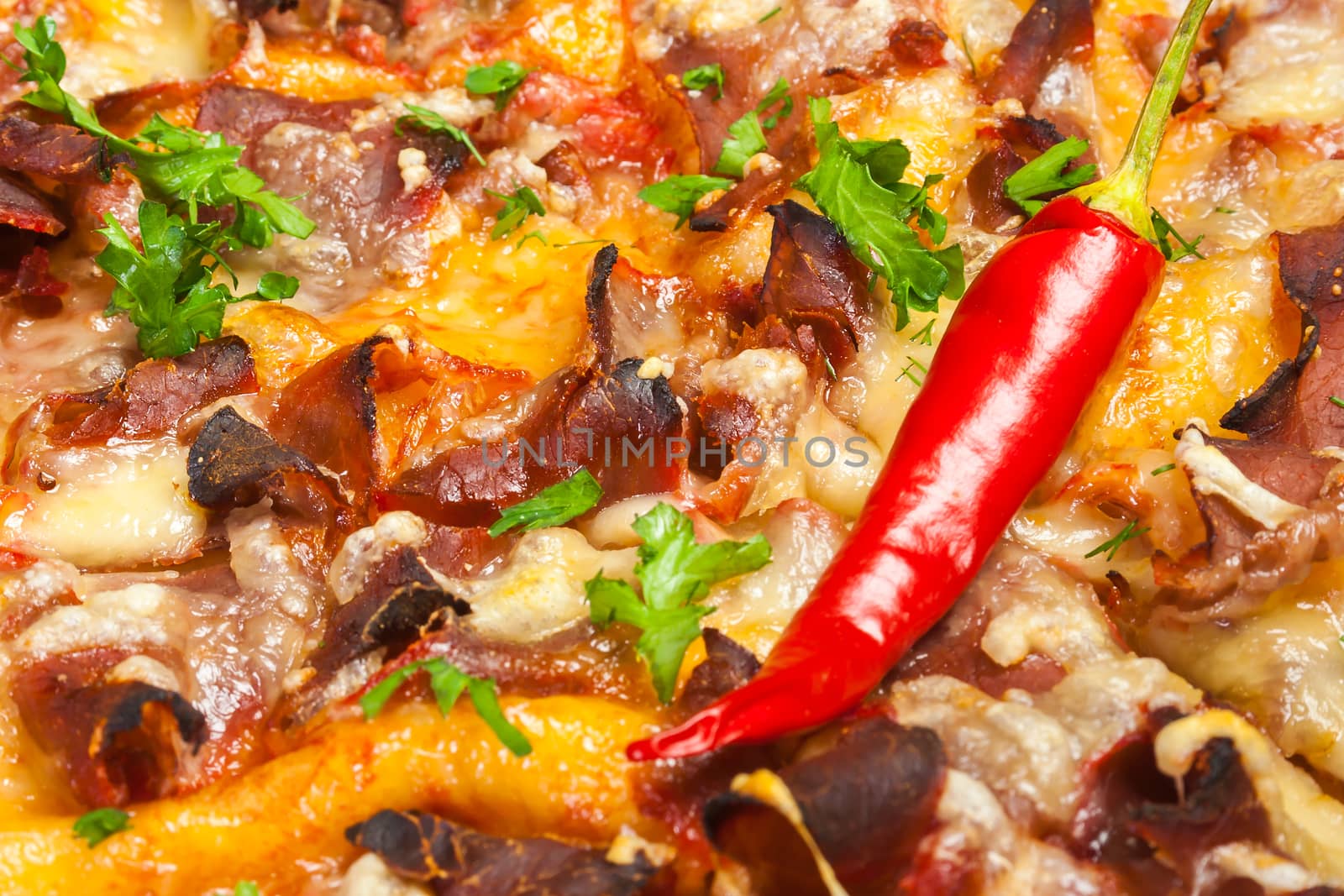 pizza with chili peppers, bacon; salami and cheese, close-up