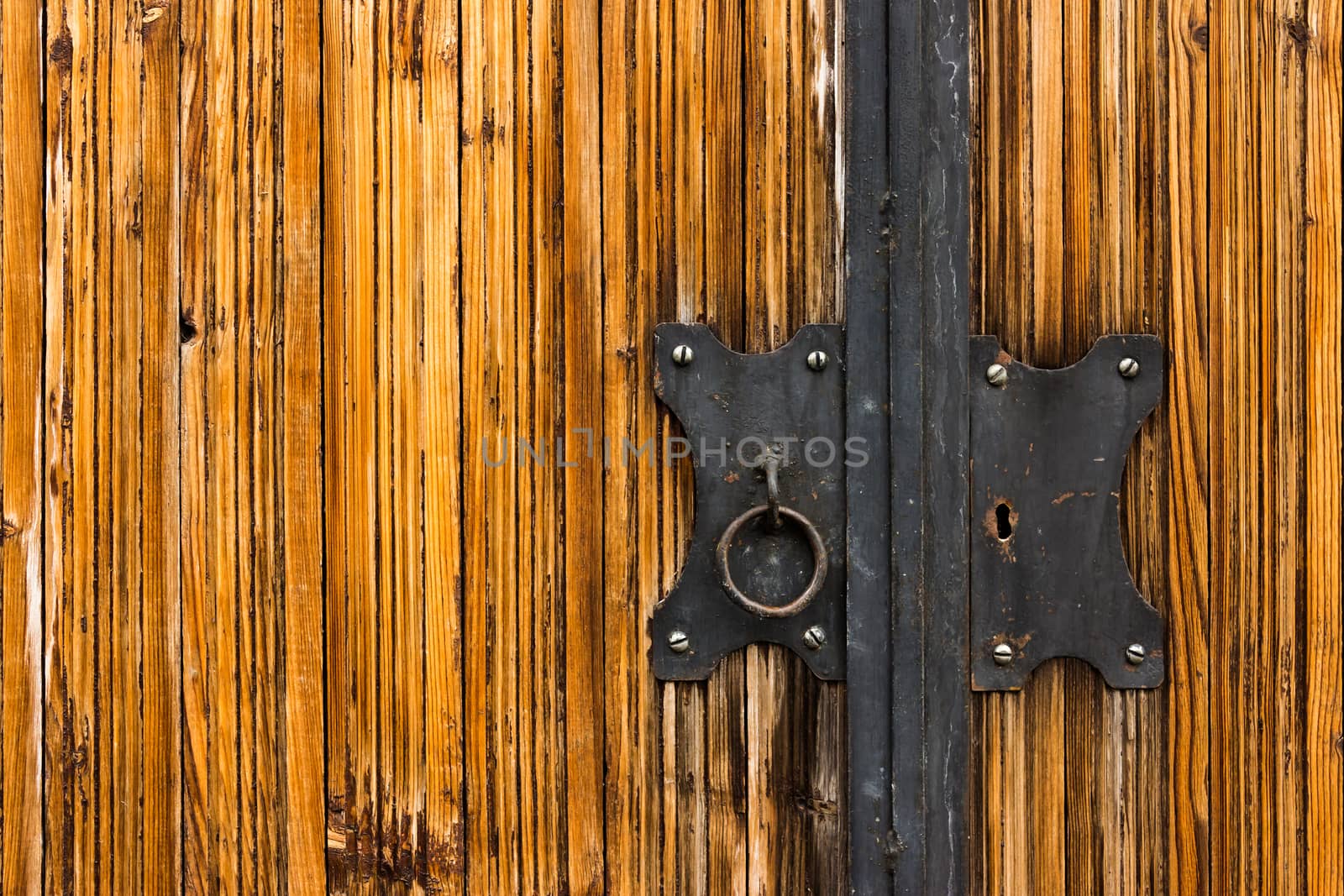 black door lock with a pen on a light wooden coating Varnishing