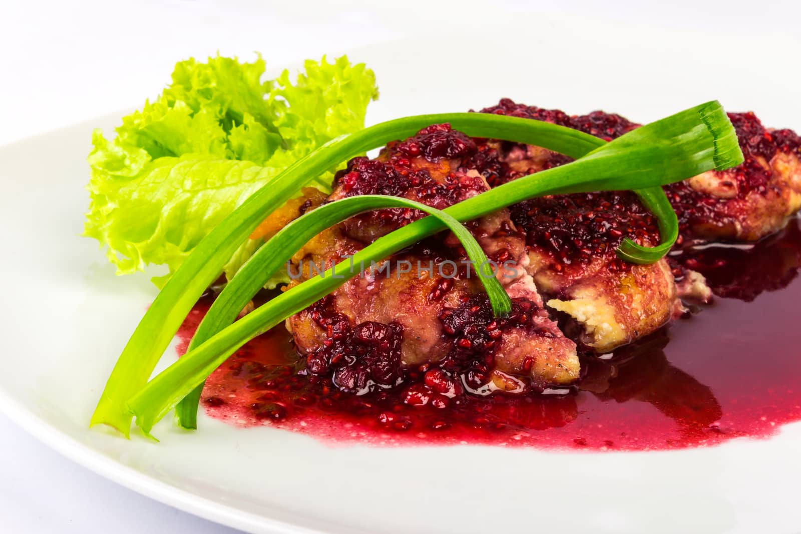 baked meat in a raspberry sauce with onion and lettuce