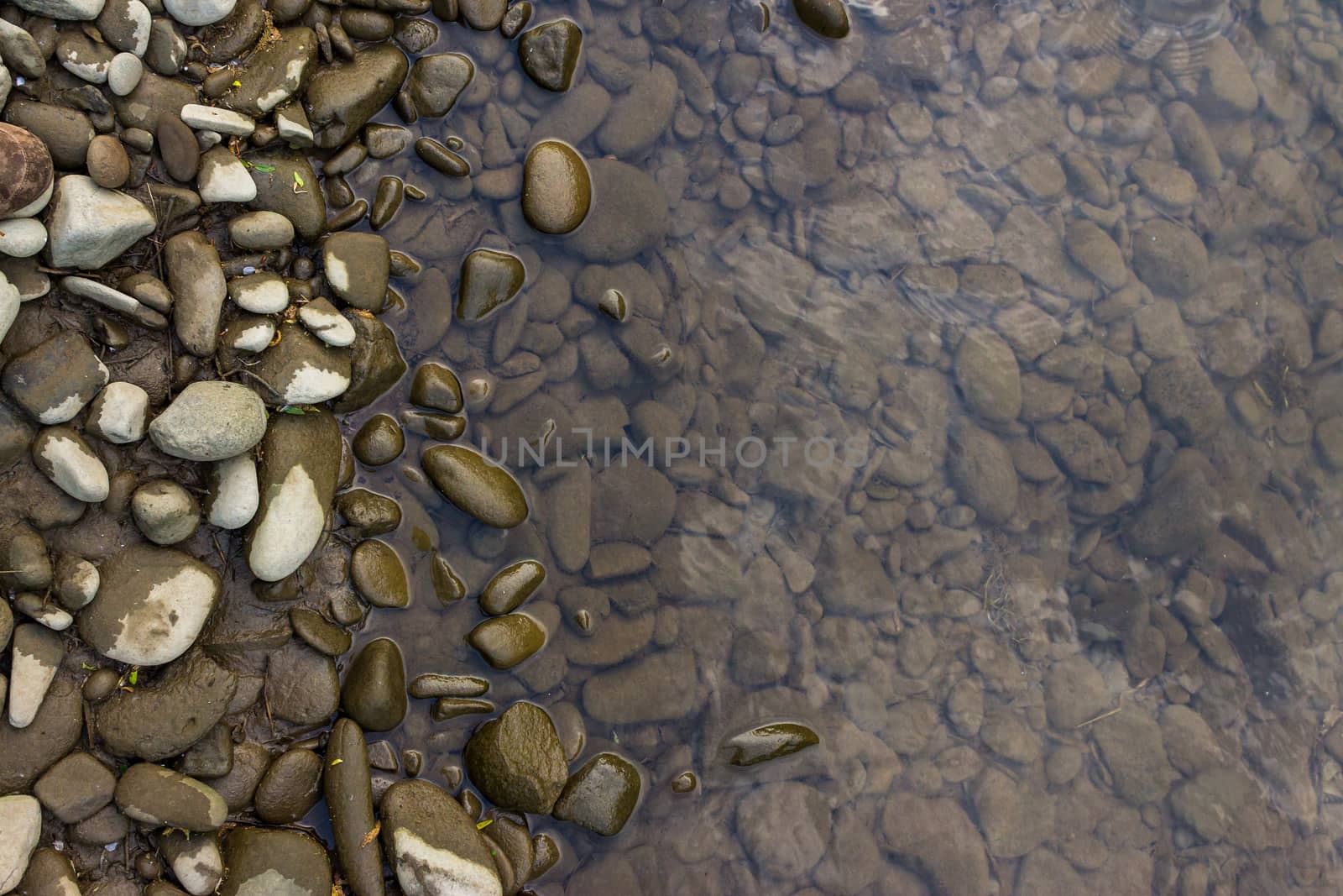 narrow shore with smooth river stones, and gray water