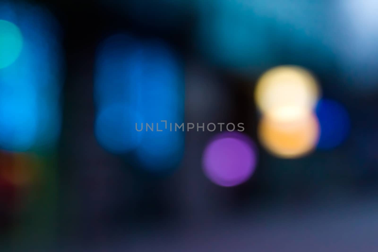 abstract blur evening urban street lighting. Using yellow, blue and purple color on a dark blue background.