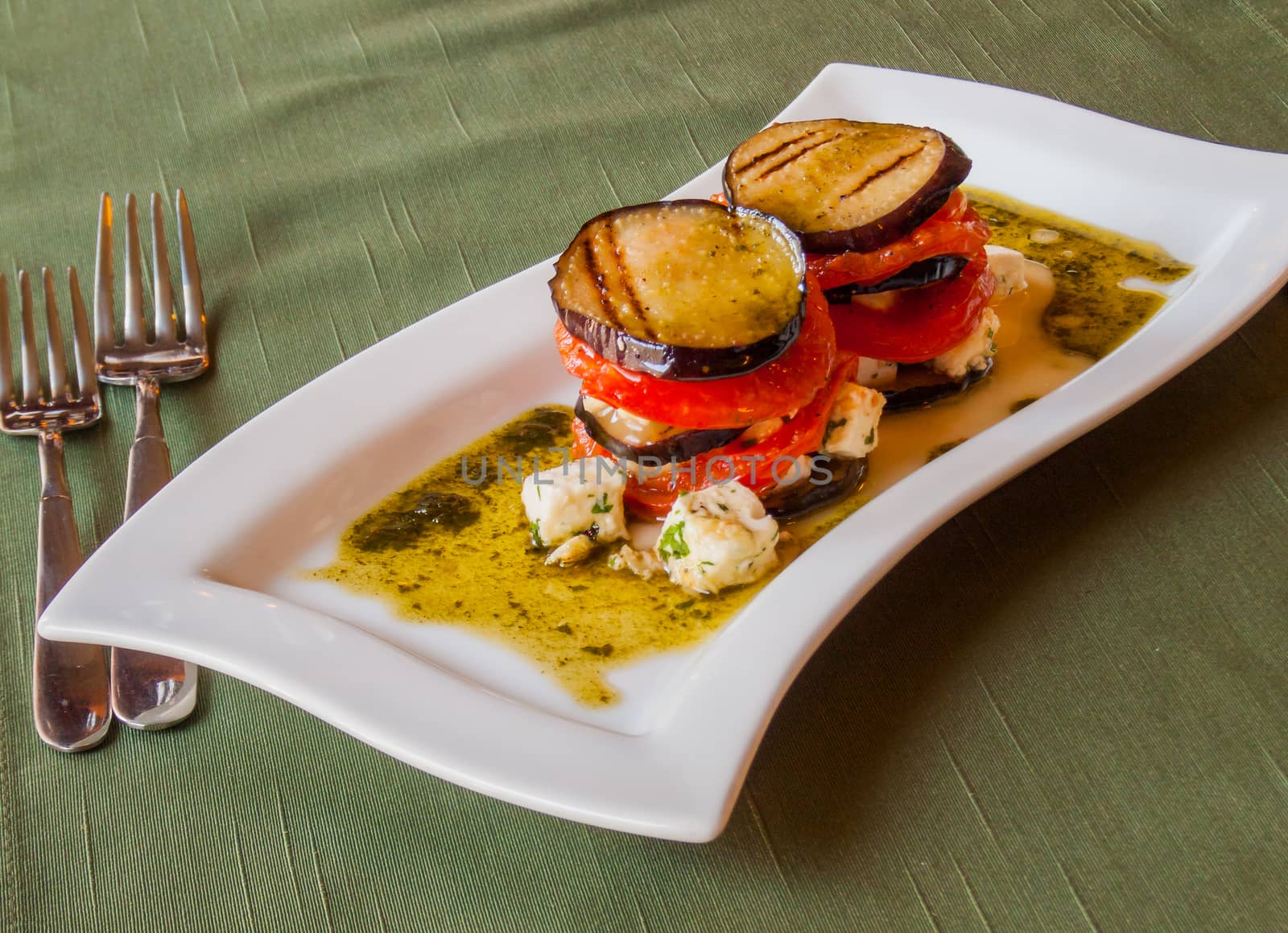 traditional italian crispy grilled eggplant with fresh tomatoes sliced​​, in olive sauce with cubes of Greek feta cheese