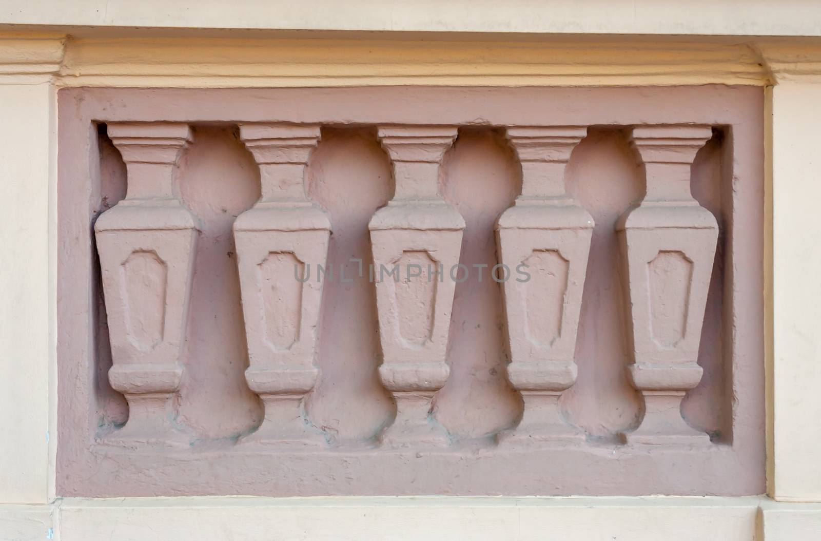 texture of five pink columns on the facade of an old building