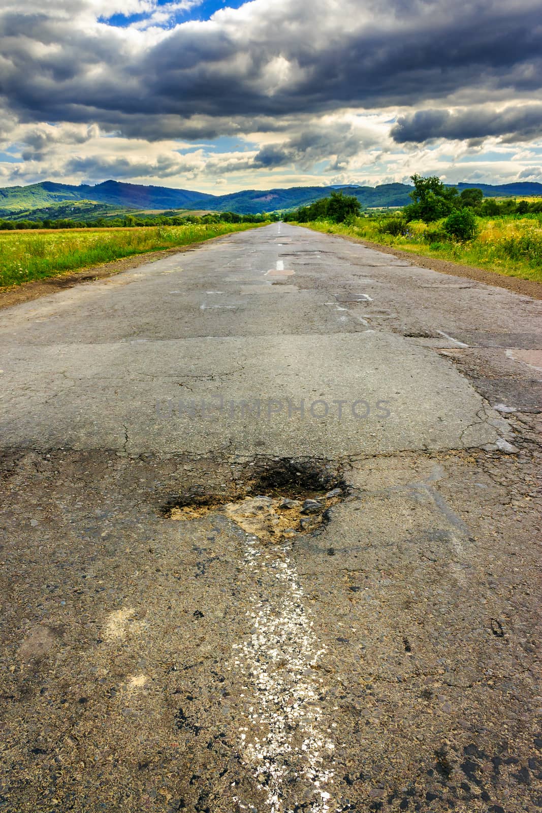 broken highway with hole in the direction of mountains