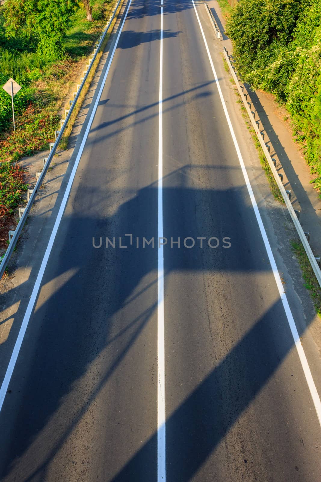 shadow on an empty road early in the morning. view from the top