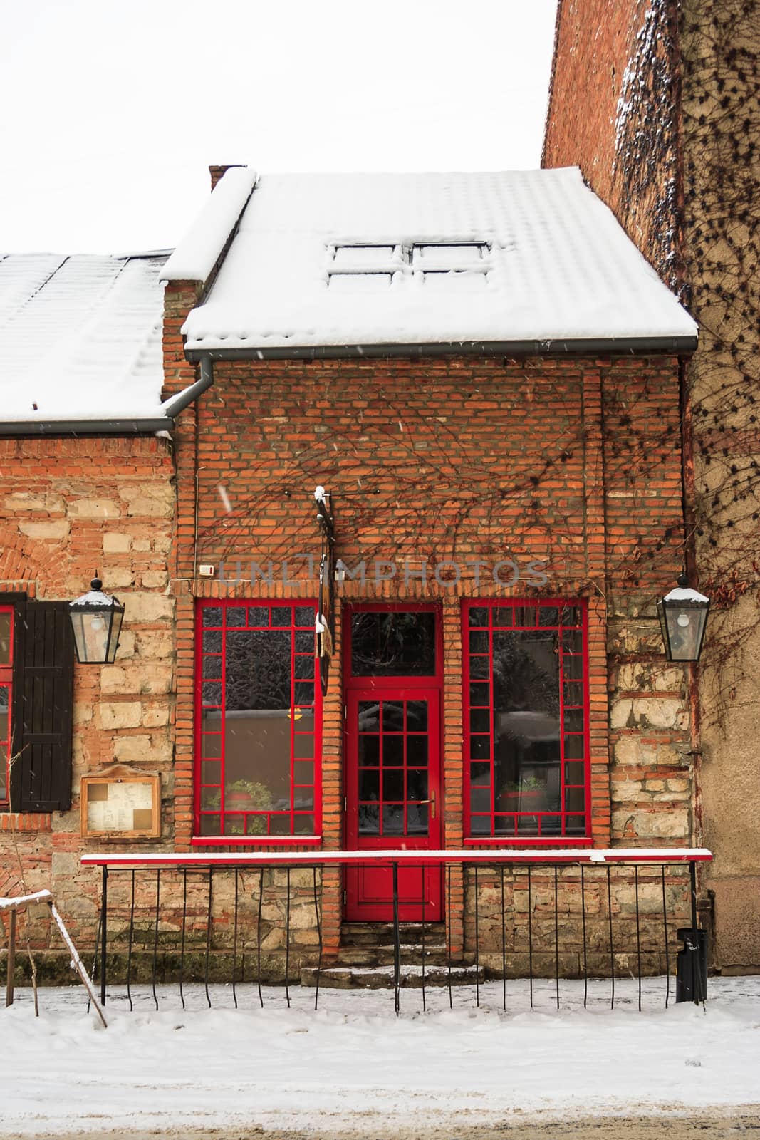 old pub with red windows and a door in winter