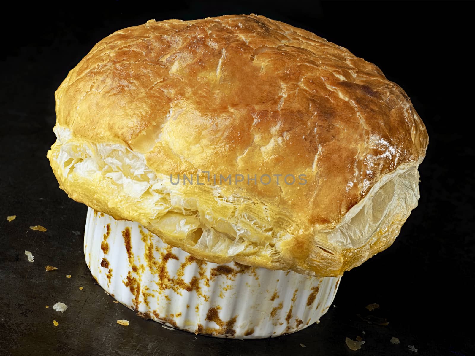 close up of rustic golden english meat pot pie with flaky crust