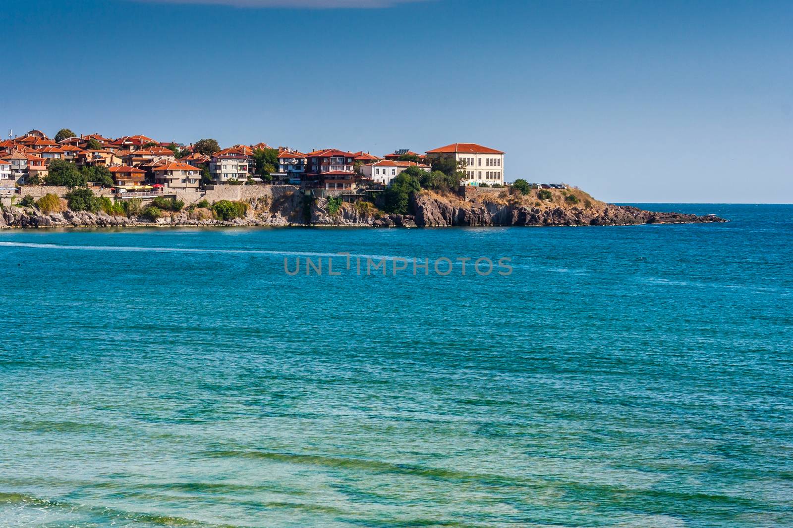 ancient city on a rocky promontory of the peninsula near the sea. sea ​​with small waves and a trace of water bike