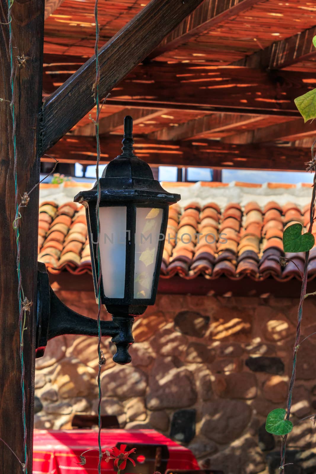 black lantern nailed to a wooden pillar of the summer terrace