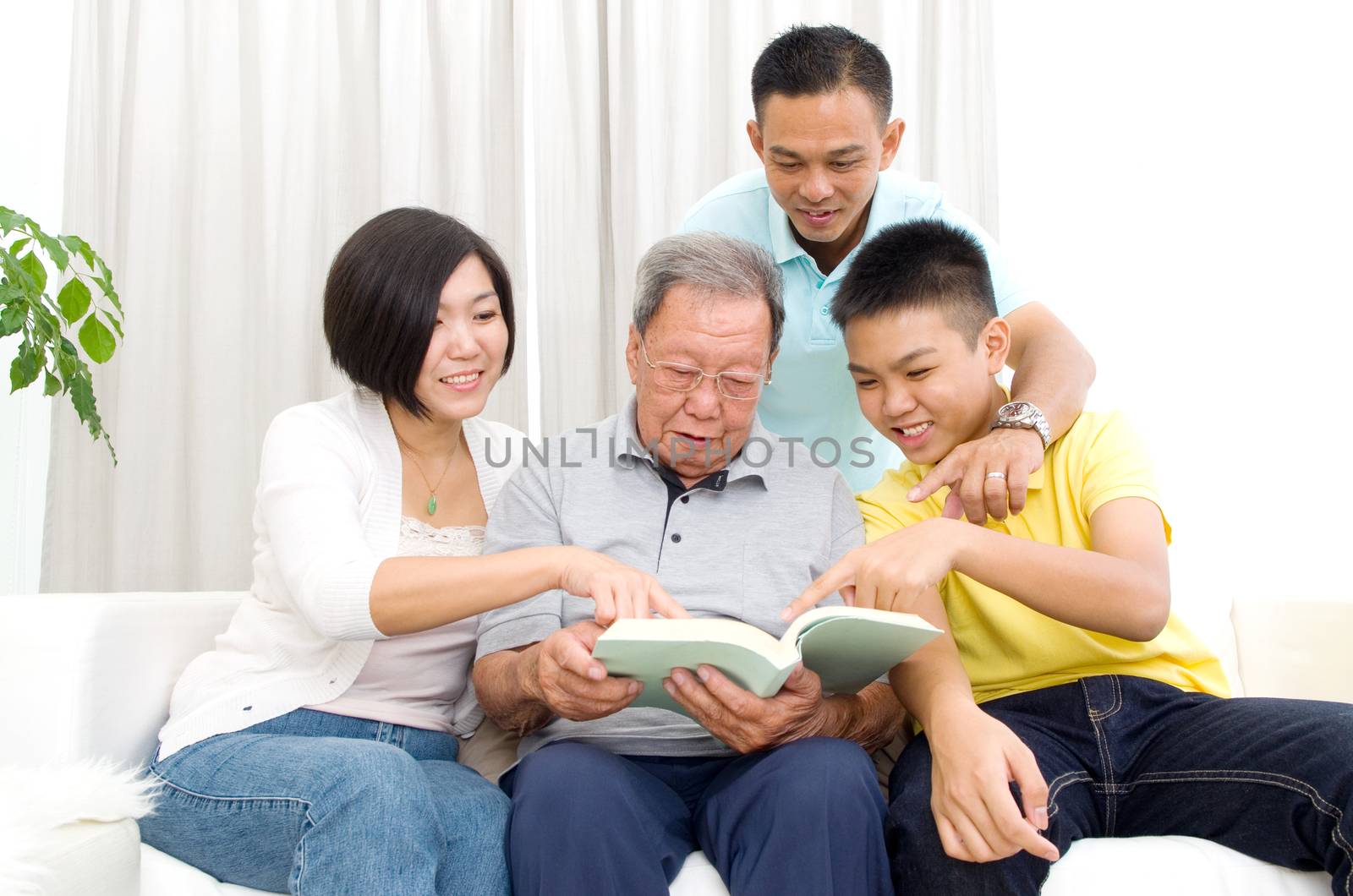 Asian family reading book at home