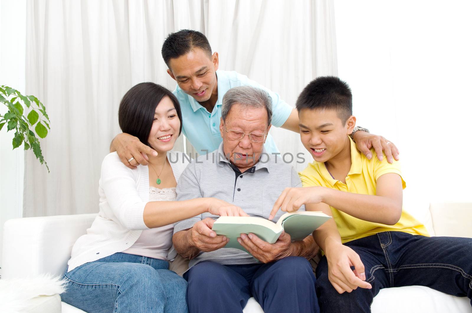 Asian family reading book at home