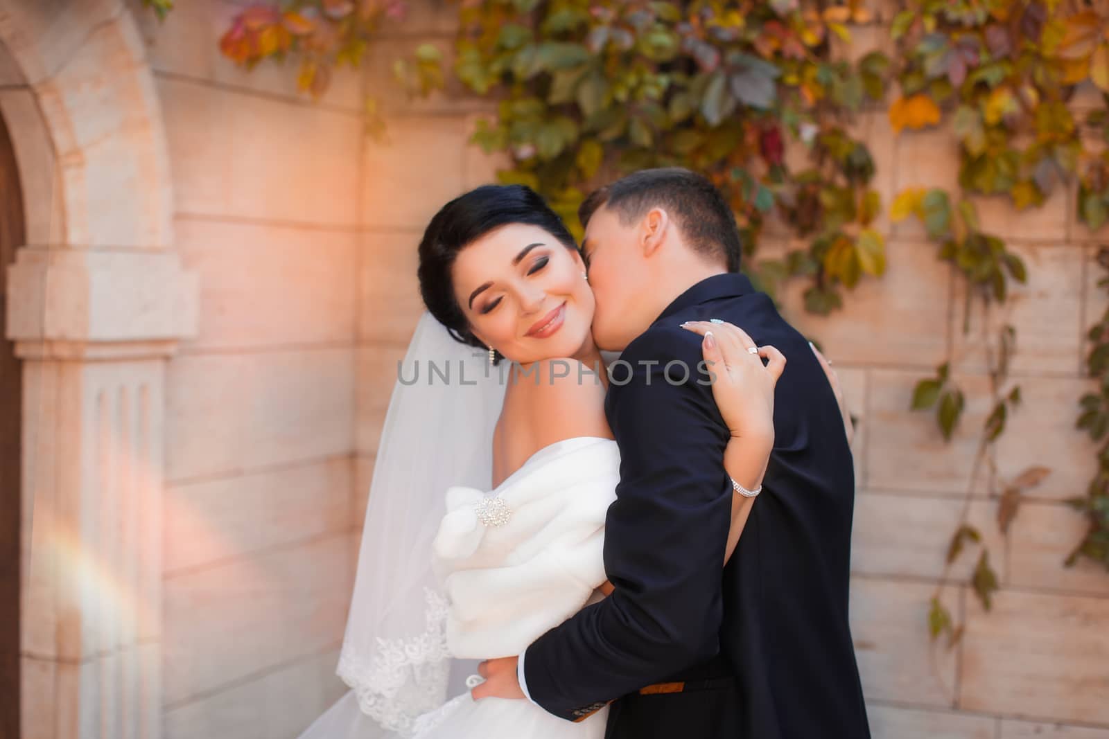 Stylish happy wedding couple on the background beautiful renaissance old castle. Romantic newlywed groom and bride.