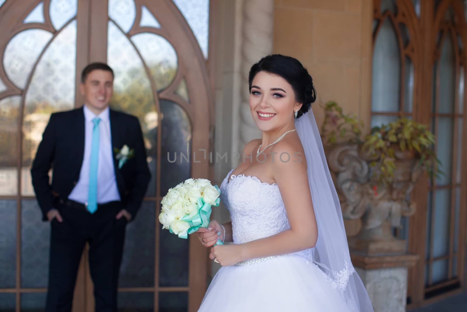 Stylish newlyweds posing against the retro door