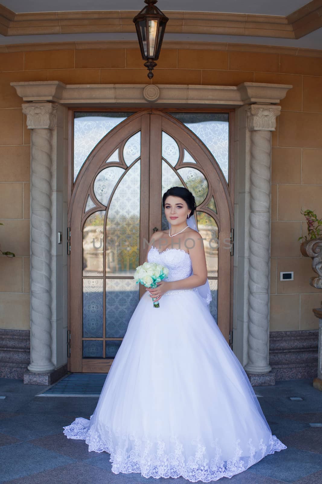 Bride with a bouquet on the background of the door by lanser314