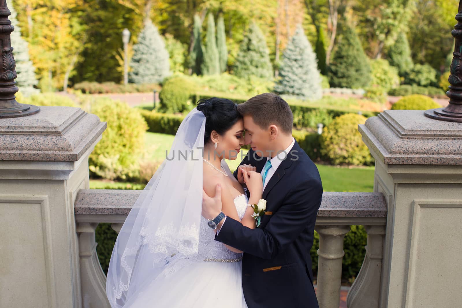 The groom tenderly embraced the happy bride in the summer park