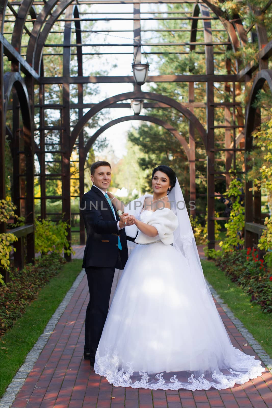 The groom tenderly embraced the happy bride in the summer park