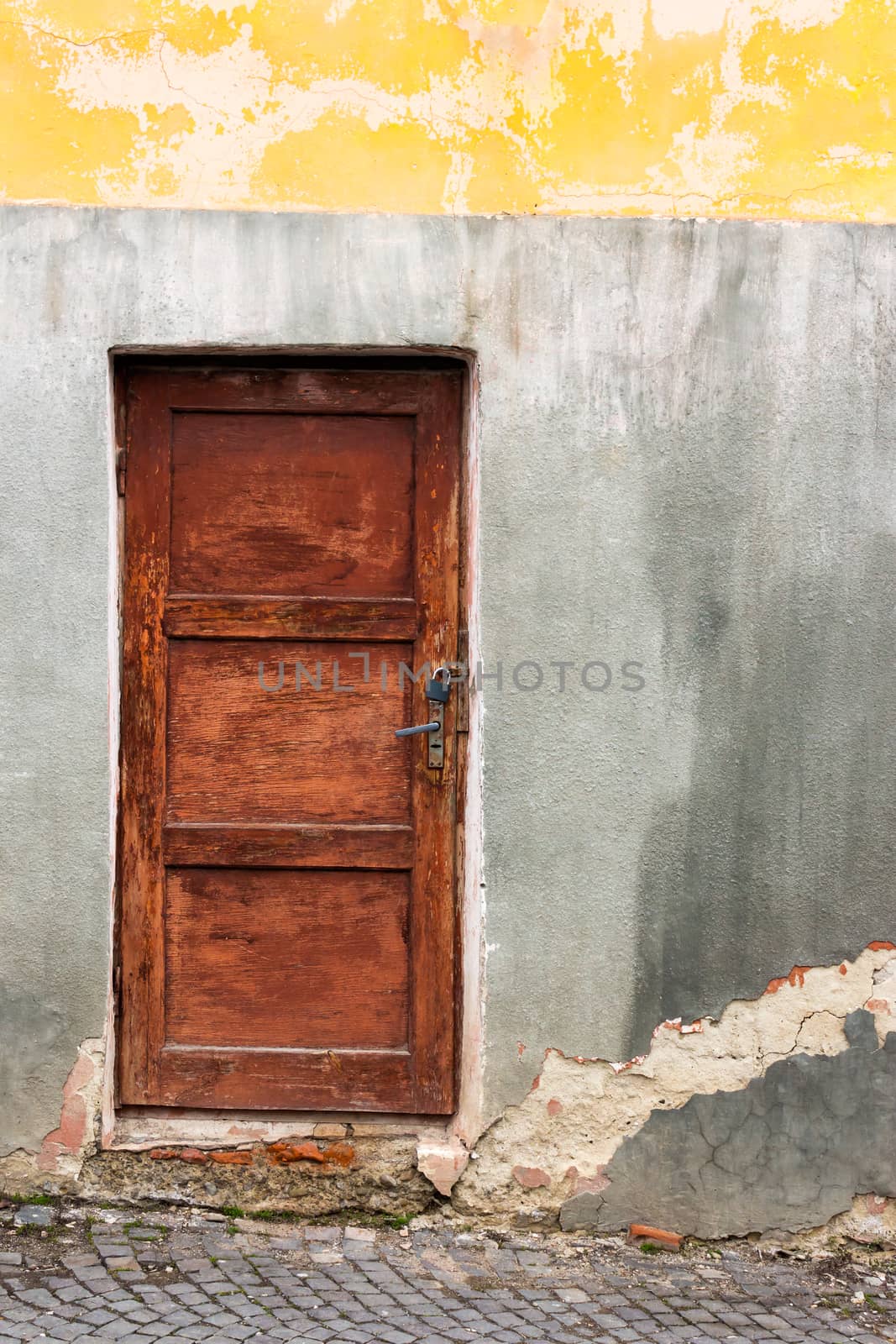 old wooden door frame with lock granary   on the old cracked wall