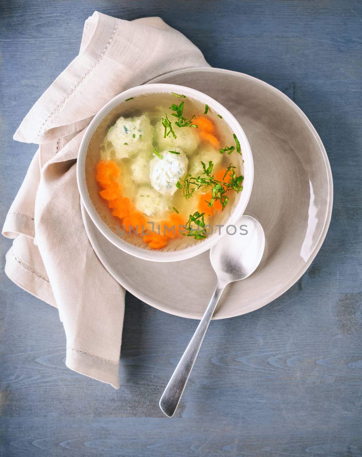 Soup with chicken meatballs and vegetables on a table