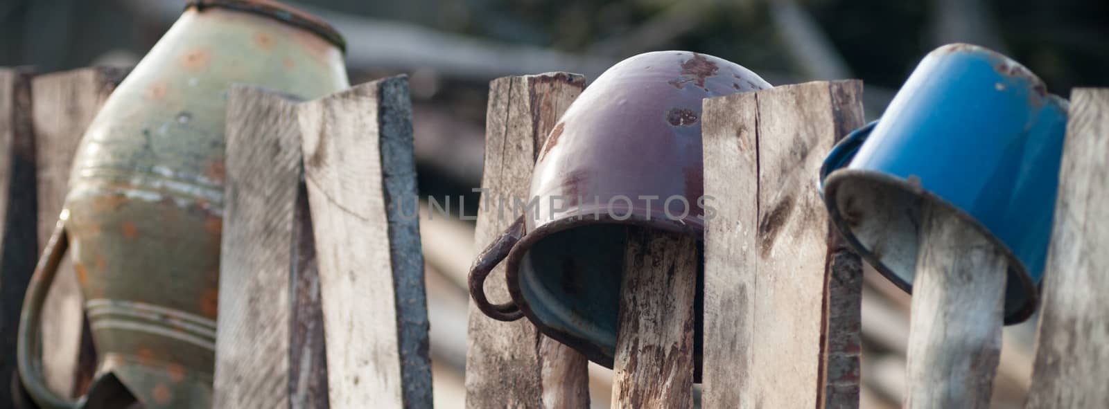Old wooden boundary fence with nails on sunny day