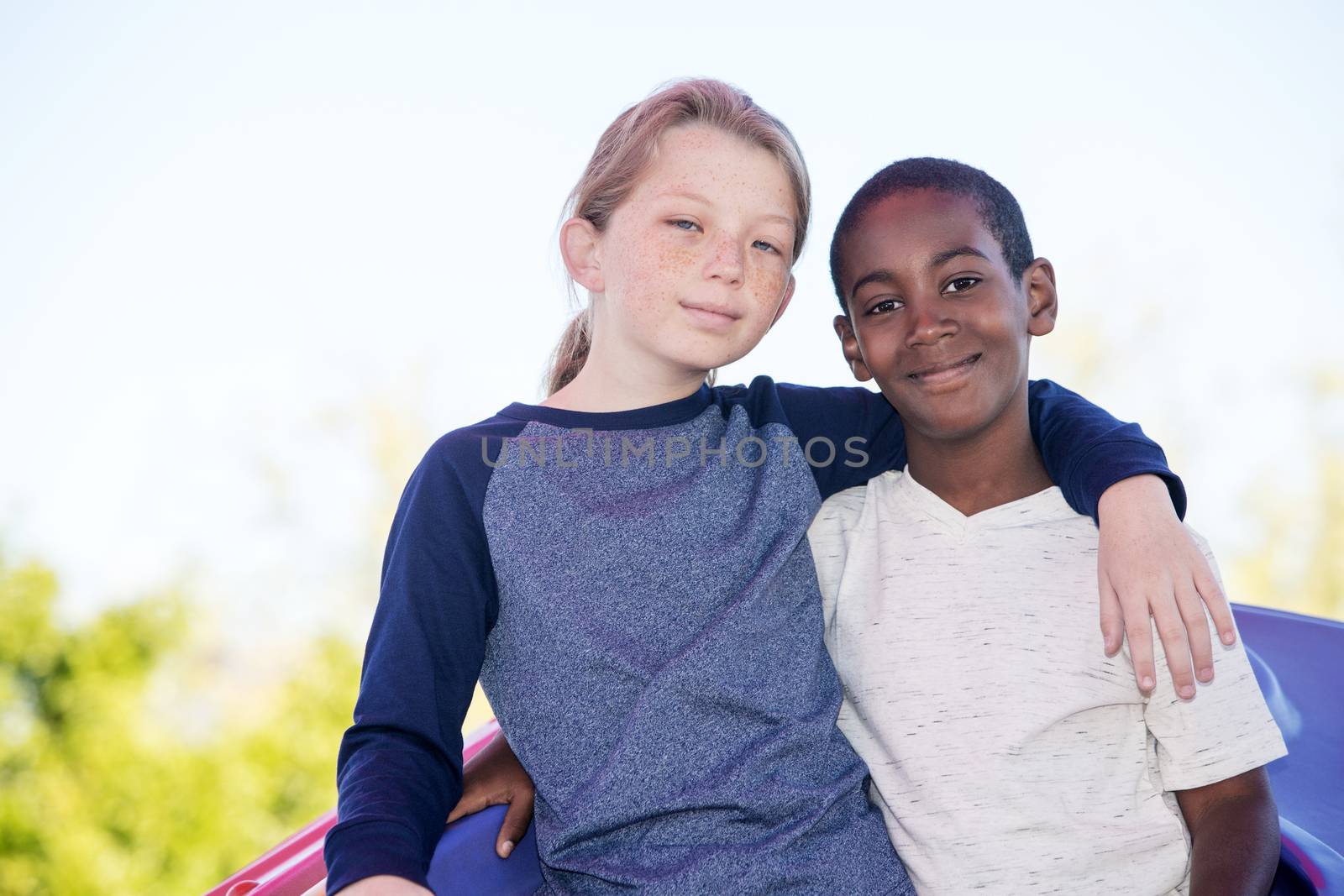 Calm cheerful boy with cute adopted brother embracing outside