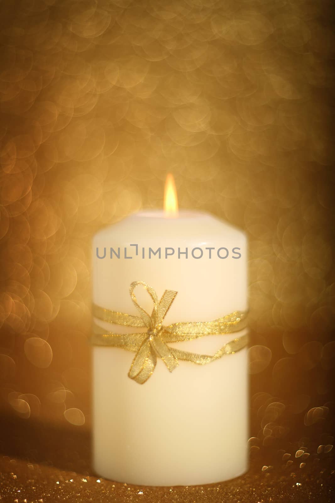 Decorative christmas candle on golden shiny bokeh background