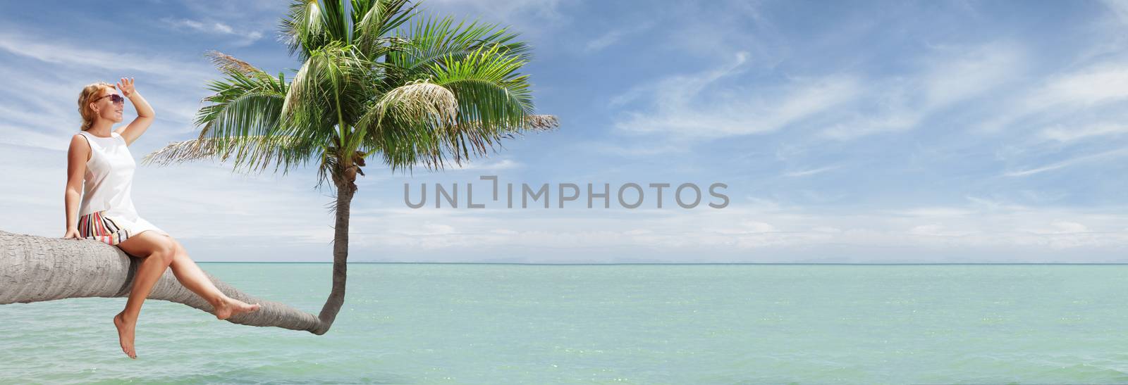 view of nice young lady sitting on palm  on tropical beach. banner.