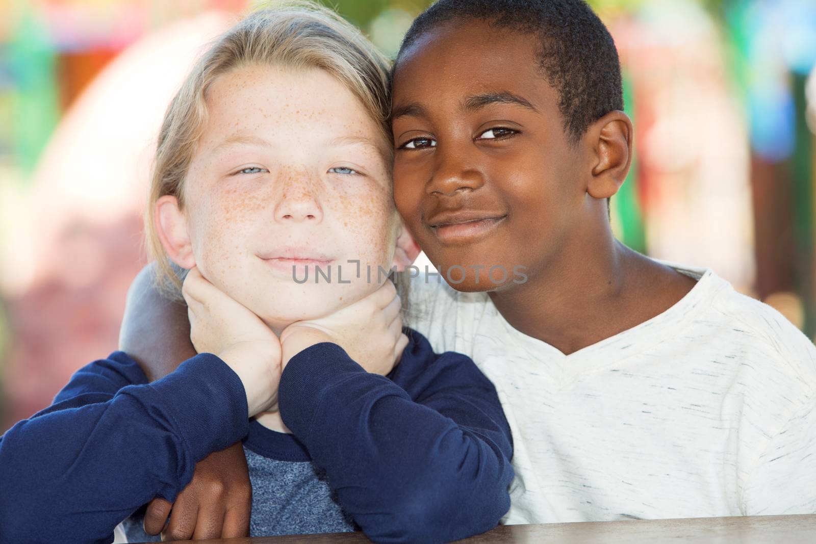 Pair of adopted brothers sitting close to each other outside