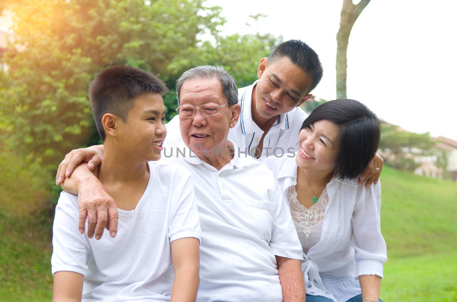 Portrait Of Multi-Generation Chinese Family Relaxing In Park 