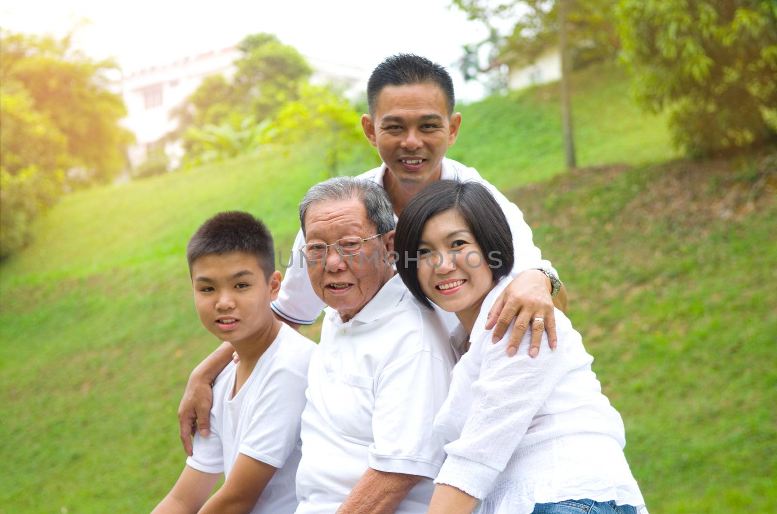 Portrait Of Multi-Generation Chinese Family Relaxing In Park 