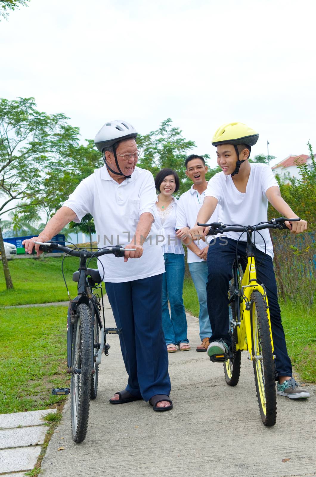 Asian  three generation Family On Cycle Ride In Countryside