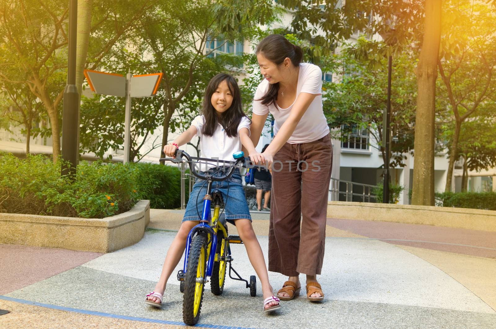 Mother and a daughter cycling bicycle at the park