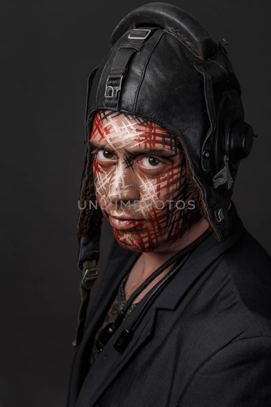 Portrait of Brutal Man with Creative Military Style Camouflage. Face Paint.  Close up on black background