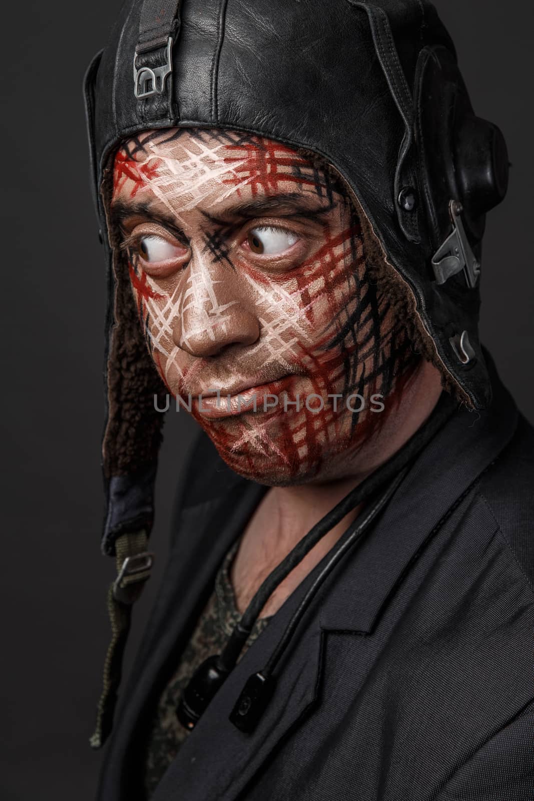 Portrait of Brutal Man with Creative Military Style Camouflage. Face Paint.  Close up on black background